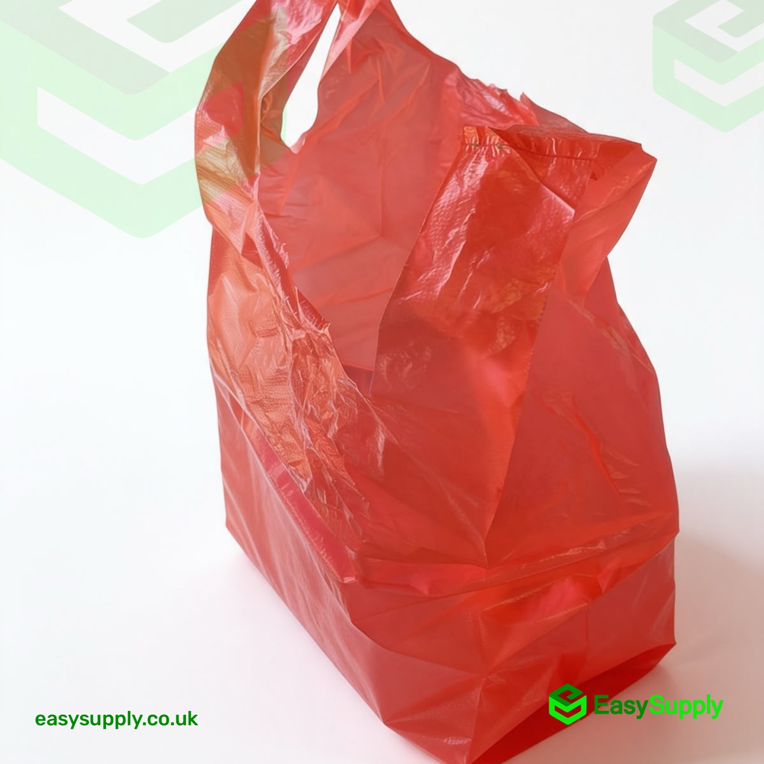 Red vest carrier bag standing filled, showing the reinforced handle and flat base
