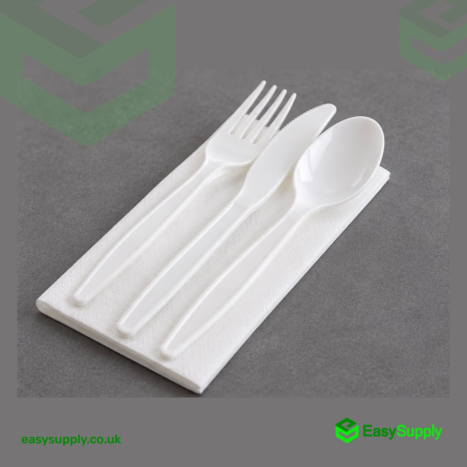 White PP 4 in 1 cutlery set - fork, knife and spoon on a paper napkin, angled view